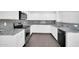 Kitchen with granite countertops, white cabinets, stainless steel appliances, and wood flooring at 25726 W Burgess Ln, Buckeye, AZ 85326