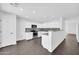 Modern white kitchen featuring stainless steel appliances, granite countertops, and sleek wood floors at 25726 W Burgess Ln, Buckeye, AZ 85326