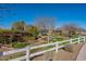 View of garden, including a pergola, raised beds and perimeter fence, with clear blue sky at 3037 E Hobart St, Gilbert, AZ 85296