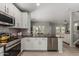 An open kitchen showcasing stainless steel appliances and a view into the bright dining and living areas at 3037 E Hobart St, Gilbert, AZ 85296