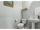 Elegant powder room with a pedestal sink, toilet, and stylish decor at 3037 E Hobart St, Gilbert, AZ 85296