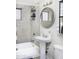 Modest bathroom with a combination shower and tub, pedestal sink, and round mirror above the toilet at 310 W Earll Dr # 102, Phoenix, AZ 85013