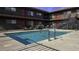 Exterior view of a community pool, with black iron pool fencing and exterior stairs to the upper-level units at 310 W Earll Dr # 102, Phoenix, AZ 85013