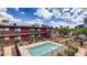 Community pool surrounded by a two-story apartment building, featuring clear blue water and safety equipment at 310 W Earll Dr # 102, Phoenix, AZ 85013