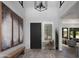 Stunning home foyer features modern decor, a dark front door, and bright, shuttered sidelight at 3133 E Silo Dr, Gilbert, AZ 85296