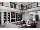Bright open-concept living room features modern decor, fireplace and leads to 2nd story loft with glass railing at 3133 E Silo Dr, Gilbert, AZ 85296