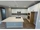 Modern kitchen featuring white cabinets, an island with a sink, and stainless steel appliances for a stylish cooking space at 3375 W Verde River Rd, San Tan Valley, AZ 85144