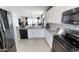 Modern kitchen with white cabinets, stainless steel appliances, and an open view to the dining area at 35068 N Sacramento Wash Rd, San Tan Valley, AZ 85144