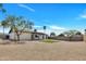 Large backyard with gravel, a small grass area, and mature trees at 3614 W Danbury Dr, Glendale, AZ 85308