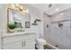 Modern bathroom with white vanity, stylish mirror, floating shelves and walk-in shower at 3614 W Danbury Dr, Glendale, AZ 85308