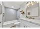 Modern bathroom featuring a shower over tub, white vanity, and gold accents at 3614 W Danbury Dr, Glendale, AZ 85308