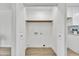 White laundry closet with wood shelving, providing a clean and organized space for laundry appliances at 3614 W Danbury Dr, Glendale, AZ 85308