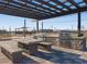 Outdoor kitchen and dining area with built-in grill, bar area, and concrete patio with seating at 36972 W Santa Maria St, Maricopa, AZ 85138
