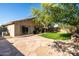 Charming backyard with a stone patio, grassy area, and mature trees, ideal for relaxation and entertainment at 3713 W Nancy Ln, Phoenix, AZ 85041