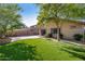 Well-kept backyard featuring artificial turf, stone patio, and mature trees for a private outdoor space at 3713 W Nancy Ln, Phoenix, AZ 85041