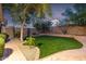 Lush backyard featuring a well-maintained lawn, mature trees, and a decorative stone border at 3713 W Nancy Ln, Phoenix, AZ 85041