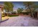 Backyard featuring artificial grass, mature landscaping and a stone patio at 3713 W Nancy Ln, Phoenix, AZ 85041
