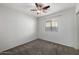 A bright bedroom featuring a ceiling fan, carpet, and a window overlooking the backyard at 3713 W Nancy Ln, Phoenix, AZ 85041