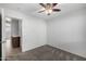 A well-lit bedroom featuring a ceiling fan, plush carpet, and an ensuite bathroom at 3713 W Nancy Ln, Phoenix, AZ 85041