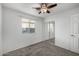 A cozy bedroom with a window, ceiling fan, plush carpet and mirrored closet doors at 3713 W Nancy Ln, Phoenix, AZ 85041