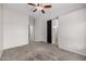 Spacious bedroom with a ceiling fan, gray carpet, access to a bathroom and closet at 3713 W Nancy Ln, Phoenix, AZ 85041