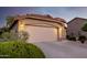 Two-car garage with a long driveway and desert landscaping in the front of the house at 3713 W Nancy Ln, Phoenix, AZ 85041