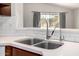 Close-up of stainless steel sink and faucet fixtures, with a view of the backyard at 3713 W Nancy Ln, Phoenix, AZ 85041