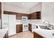 Well-lit kitchen featuring stainless steel appliances, dark wood cabinets, and bright white countertops at 3713 W Nancy Ln, Phoenix, AZ 85041