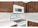 Modern kitchen with white appliances, dark cabinetry, and bright countertops at 3713 W Nancy Ln, Phoenix, AZ 85041