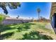View of a large, manicured backyard with a block wall, foliage, and well maintained grass at 3801 E Captain Dreyfus Ave, Phoenix, AZ 85032