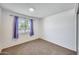 Bright bedroom featuring a window with purple curtains and neutral carpeting at 3801 E Captain Dreyfus Ave, Phoenix, AZ 85032