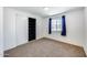 Cozy bedroom with neutral carpeting, window with blue curtains, and a closet at 3801 E Captain Dreyfus Ave, Phoenix, AZ 85032