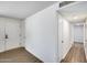 Hallway with wood-look floors and white walls, leading to various rooms at 3801 E Captain Dreyfus Ave, Phoenix, AZ 85032