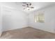 Bright bedroom featuring neutral carpet, ceiling fan, and windows for natural light at 40066 W Jenna Ln, Maricopa, AZ 85138