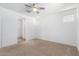 Bright bedroom includes neutral carpet, ceiling fan, ensuite access, and window for light at 40066 W Jenna Ln, Maricopa, AZ 85138