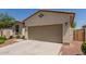 Two-car garage and desert landscaping offer a low-maintenance and practical exterior at 40066 W Jenna Ln, Maricopa, AZ 85138