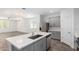 Open-concept kitchen with an island, stainless steel appliances, and stylish pendant lighting at 40066 W Jenna Ln, Maricopa, AZ 85138