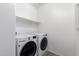 Laundry room features front loading LG washer and dryer with storage shelves and wood look floors at 40066 W Jenna Ln, Maricopa, AZ 85138
