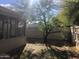 Backyard featuring a mature tree, wooden fence, and screened in patio at 4042 E Carson Rd, Phoenix, AZ 85042
