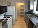Charming kitchen featuring white appliances, light wood flooring, and a pantry at 4042 E Carson Rd, Phoenix, AZ 85042