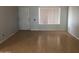 Neutral living room featuring light wood floors, a large window and white door at 4042 E Carson Rd, Phoenix, AZ 85042