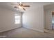 Bright bedroom featuring a ceiling fan and large window for natural light at 41767 W Somerset Dr, Maricopa, AZ 85138