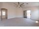 Spacious living room with neutral carpet, ceiling fan, and sliding glass doors at 41767 W Somerset Dr, Maricopa, AZ 85138