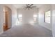 Large living room with a ceiling fan and multiple windows bringing in natural light at 41767 W Somerset Dr, Maricopa, AZ 85138