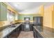 Kitchen with stone counters, black appliances, and green cabinets at 4307 E Shetland Dr, San Tan Valley, AZ 85140