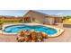 Backyard pool featuring rock waterfall, concrete deck, turf area, and storage shed; perfect for outdoor living at 4307 E Shetland Dr, San Tan Valley, AZ 85140