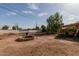 Large backyard featuring a stone fire pit and mature trees at 4501 W Crittenden Ln, Phoenix, AZ 85031