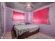 Bedroom with pink walls, bed, carpet, and ceiling fan at 4501 W Crittenden Ln, Phoenix, AZ 85031
