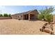 Backyard with gravel landscaping, solar panels, covered patio, grill, and a wooden planter box at 5039 S 237Th Ln, Buckeye, AZ 85326