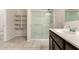 Bathroom featuring tile floors, a glass shower enclosure, and dark wood cabinets at 5039 S 237Th Ln, Buckeye, AZ 85326